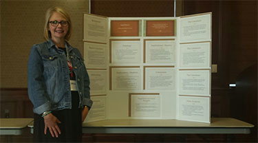 Dr. Ingrid Massey beside presentation poster
